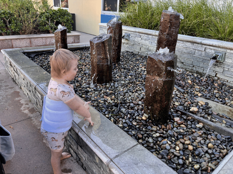 Boy with medical belt looking at water feature