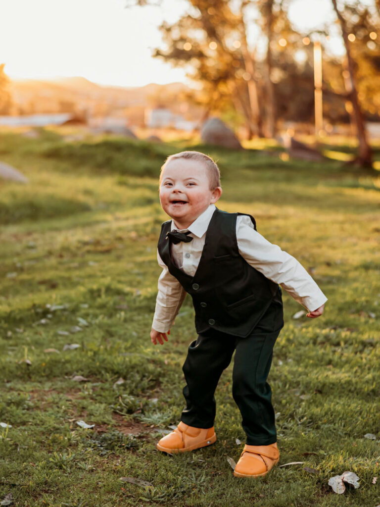 young boy wearing dressy clothes in a golden field