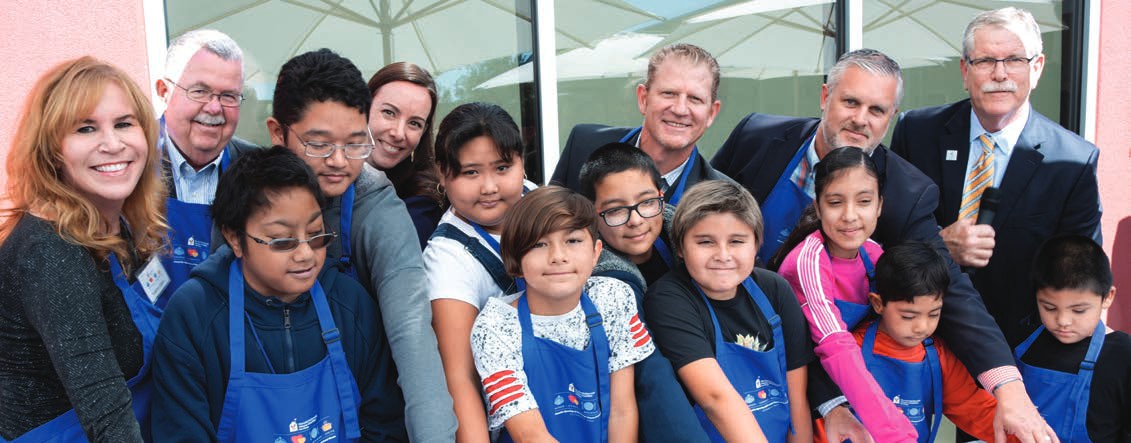 Trulette Clayes, trustees and children in aprons celebrate together in the House kitchen in 2019.