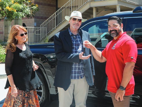 Raffle winner Tom and his wife, Sandy, receive the keys to a new Lexus from Chief Operations Officer Oscar Gomez.